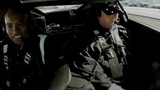 Sam Schmidt, right, prepares to take the modified Corvette for another test drive at the Indianapolis Speedway. The white dots on his cap are part of the OptiTrack motion capture system the quadriplegic Schmidt uses to control the car. (Source: Ball Aerospace and OptiTrack)